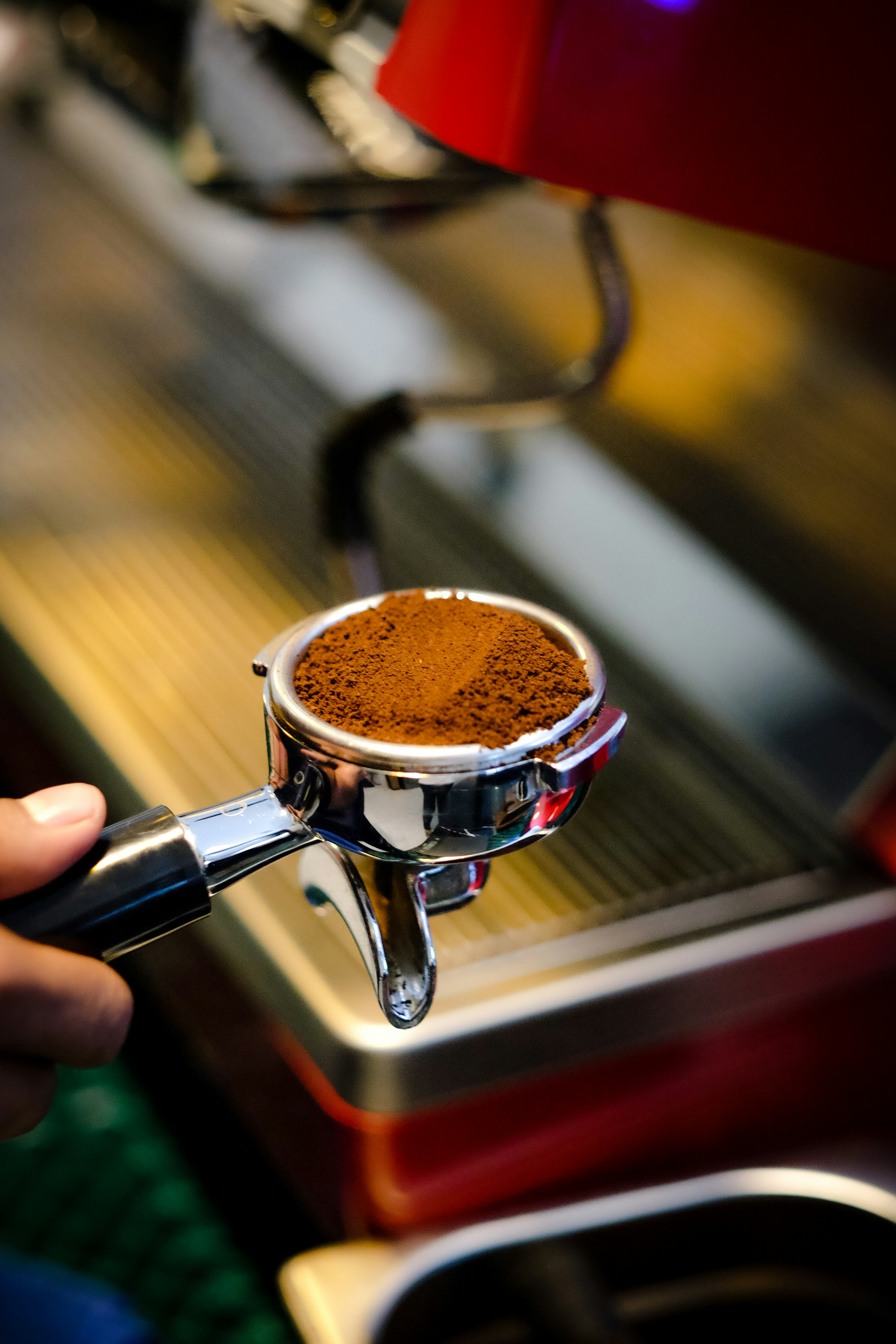 Taze öğütülmüş kahve dolu portafiltreyi elinde tutan barista